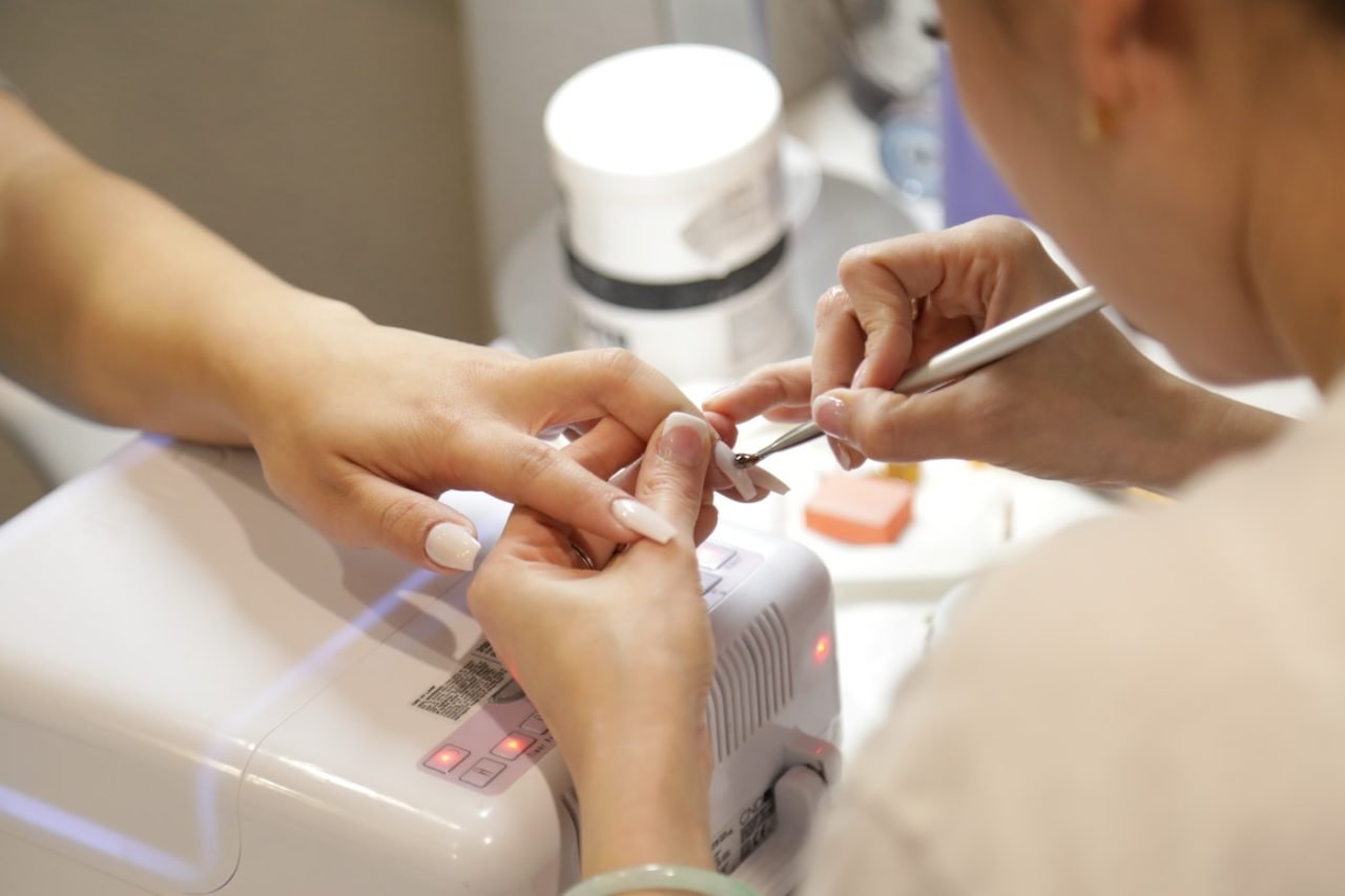 A P&T Nails Spa technician carefully shaping a client's nails